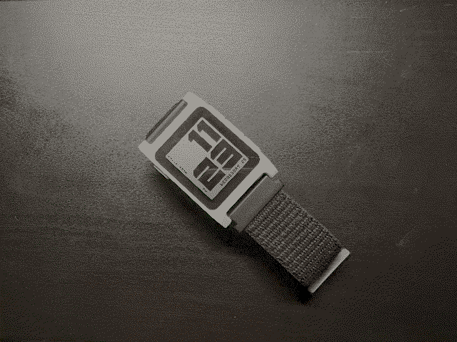 A white Pebble 2 Duo, with a black nylon strap, and the BRUTAL watchface