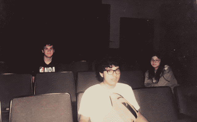 Three students sitting in a empty auditorium